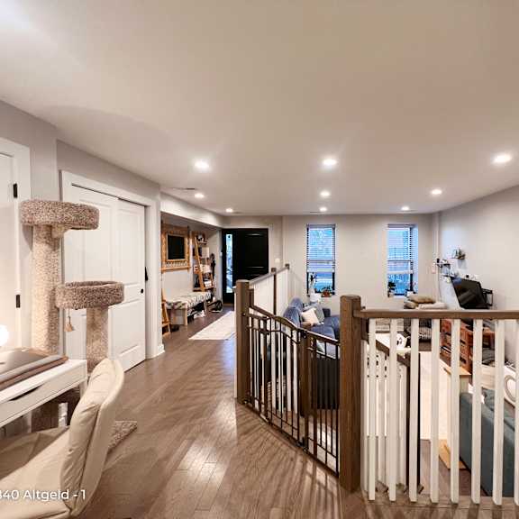 a well-lit, spacious living room with a staircase leading to the upper floor.