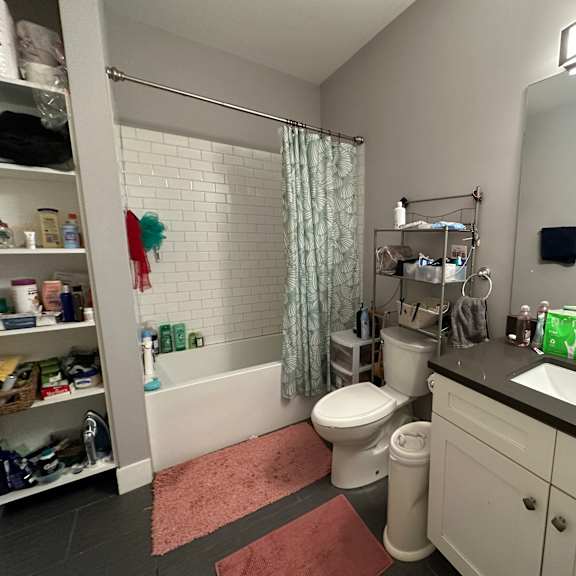 a bathroom with a toilet, sink, and shower.