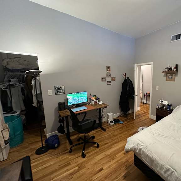 a room with a bed, desk, and chair.