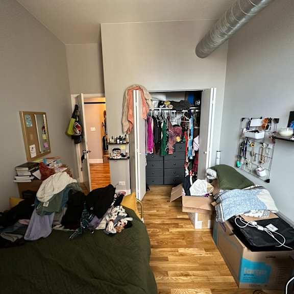 a room with a bed, a wardrobe and a desk.
