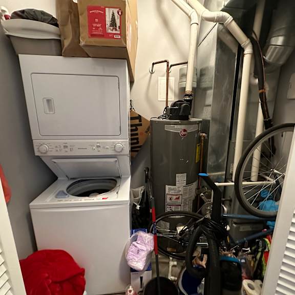 a white dryer and washer are in a small, cluttered laundry room.