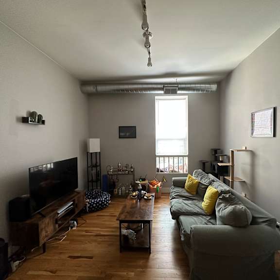 a living room with a grey couch and a wooden floor.