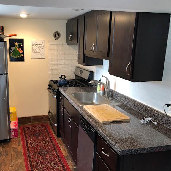 a kitchen with a stainless steel refrigerator and dark brown cabinets.