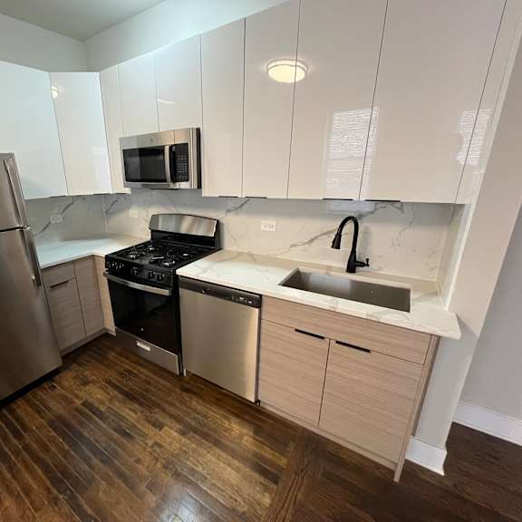 a kitchen with a stainless steel refrigerator, microwave, oven, and sink.