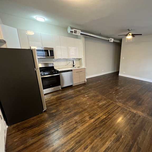 a kitchen with a black fridge, microwave, and stove.