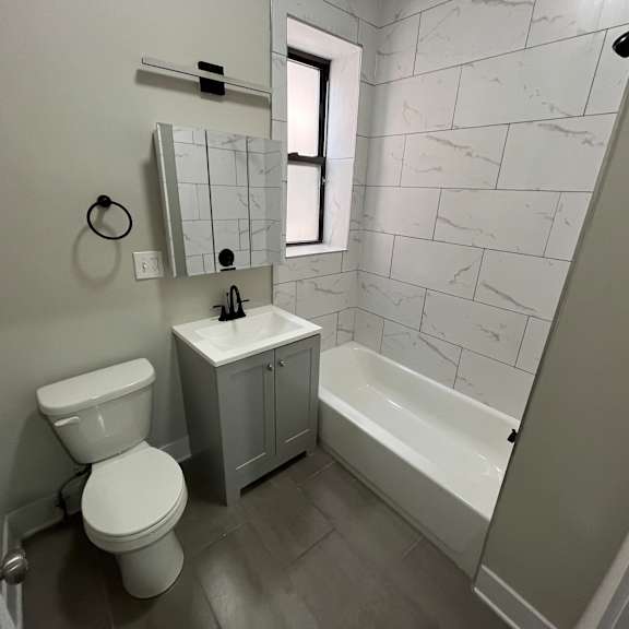a white toilet sits next to a white sink in a bathroom.
