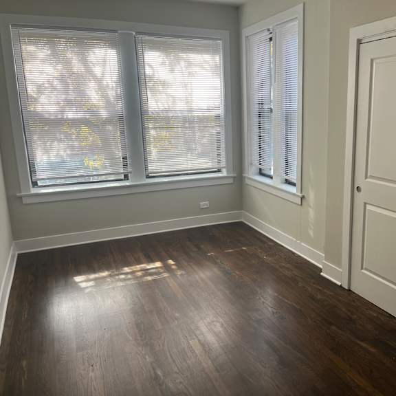 a room with a wooden floor and white walls.