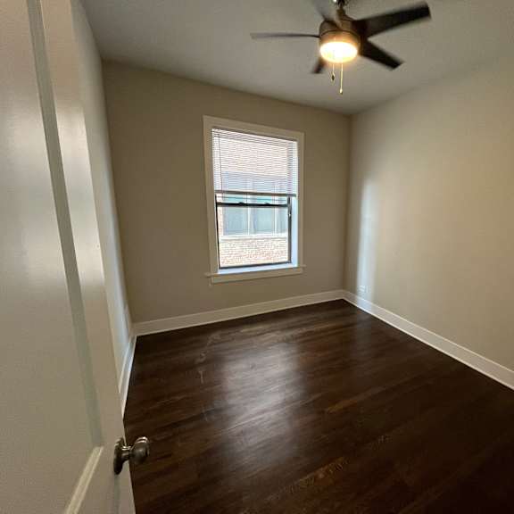 a room with a ceiling fan and a window.