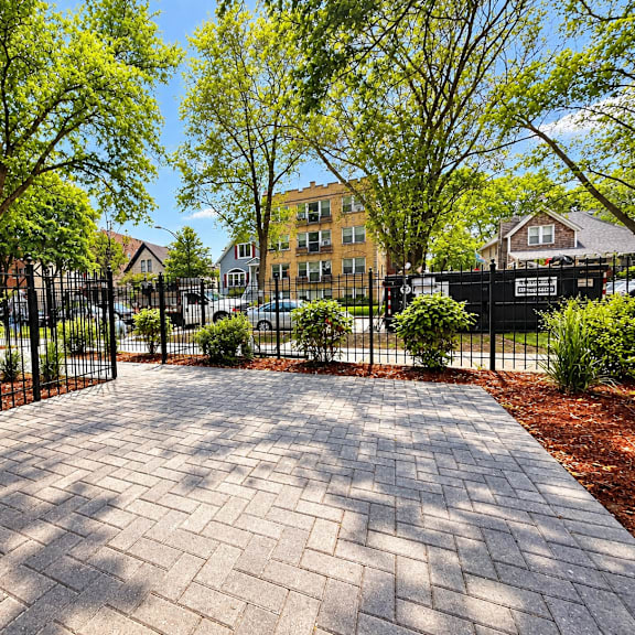 a brick pathway leads to a gated entrance.
