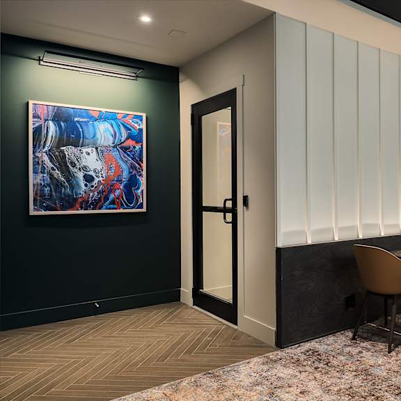 a dining room with a table and chairs and a painting on the wall