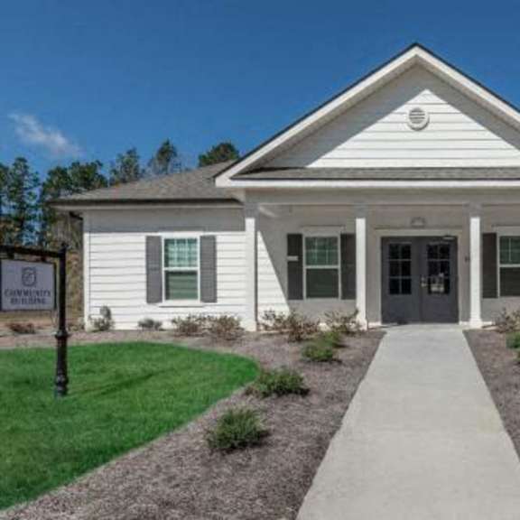 a white house with a sidewalk in front of it