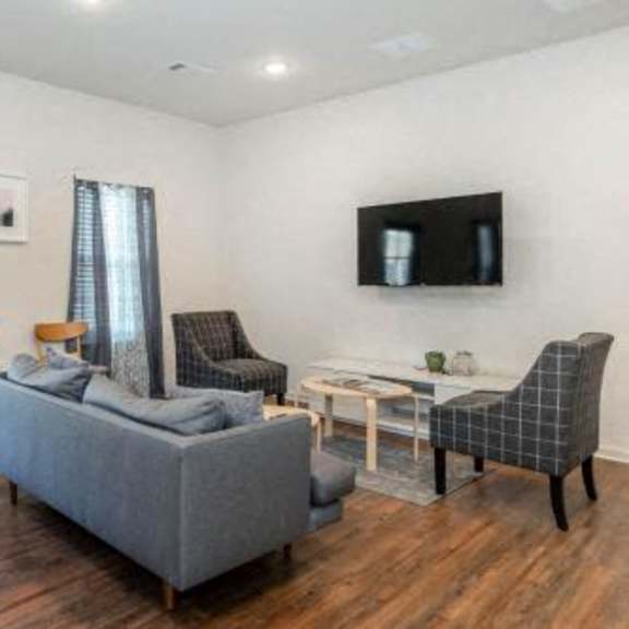 a living room with a couch and chairs and a television