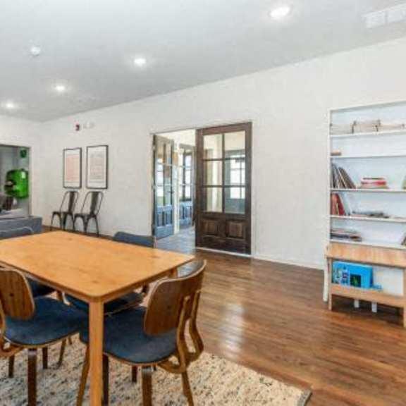 a living room with a wooden table and chairs