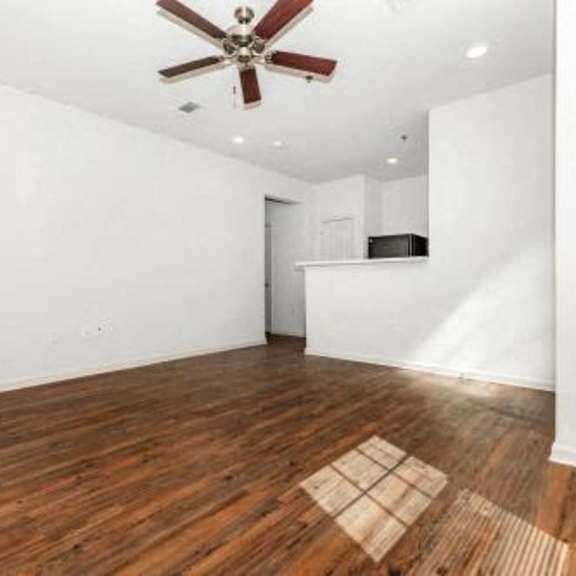 a empty living room with a ceiling fan