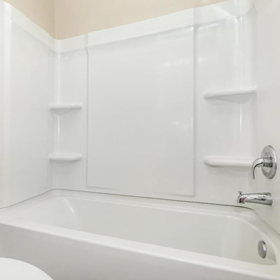 a white bathroom with a toilet and a tub