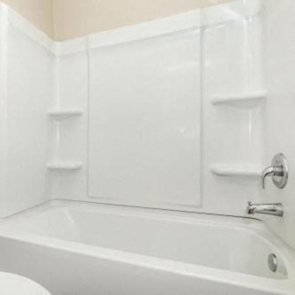 a white bathroom with a toilet and a bath tub