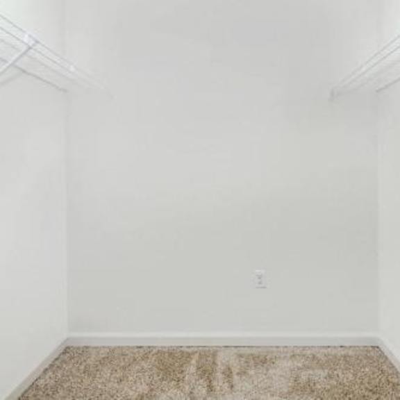 an empty room with white walls and a carpet