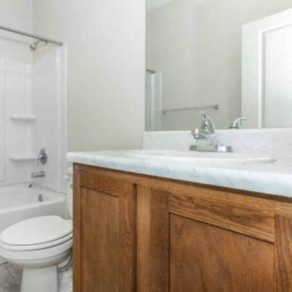 a white bathroom with a toilet and a sink