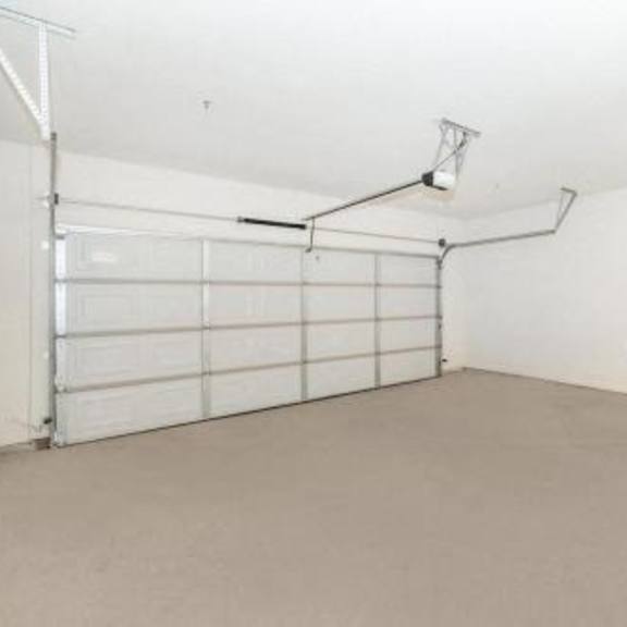 an empty garage with a white wall and a white garage door