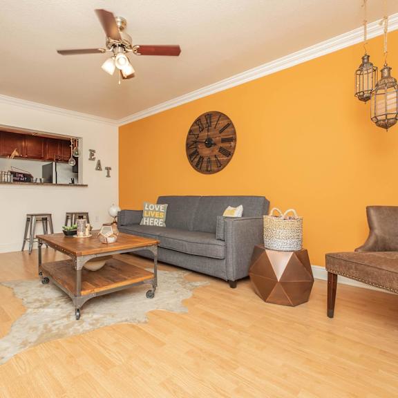 a living room with a grey couch, a wooden coffee table, and a rug on the floor. at the cove at state street apartments, baton rouge, louisiana