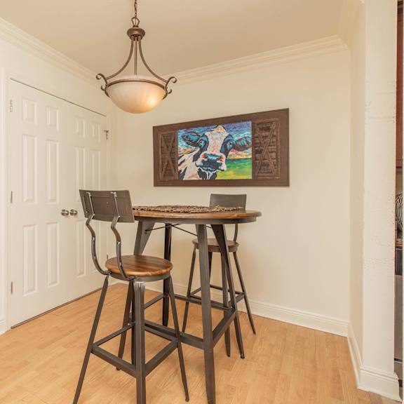 a dining room with a wooden table and chairs. at the cove at state street apartments, louisiana