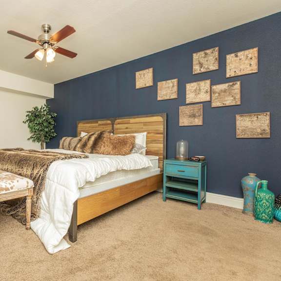 a bedroom with a bed, a chair, and a potted plant. at the cove at state street apartments, baton rouge, louisiana