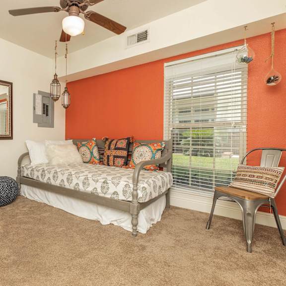 a bedroom with a bed, chair, and mirror. at the cove at state street apartments, louisiana