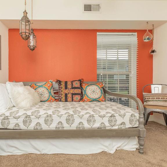 a bedroom with a bed, a chair, and a mirror. at the cove at state street apartments, baton rouge, la, 70802