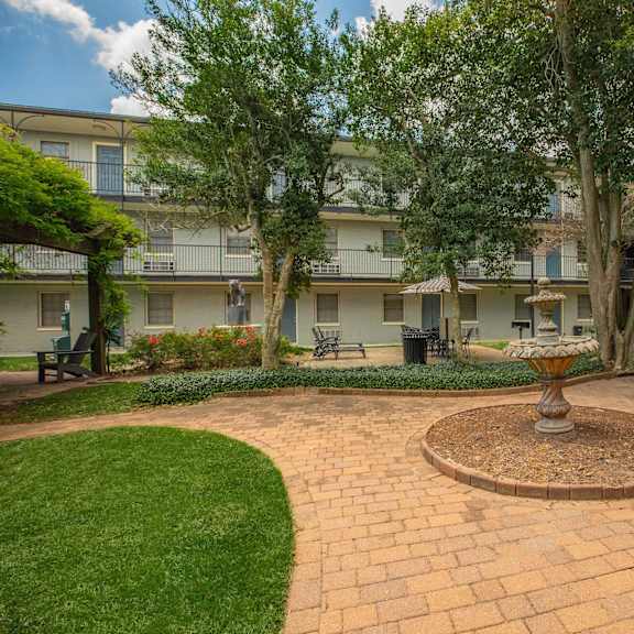a courtyard with a fountain in the middle of it. at the cove at state street apartments, baton rouge, louisiana