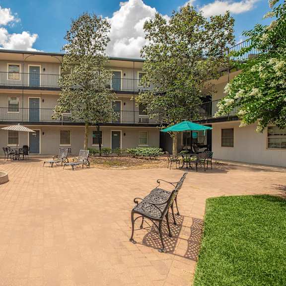 a courtyard with a fountain and chairs. at the cove at state street apartments, louisiana, 70802