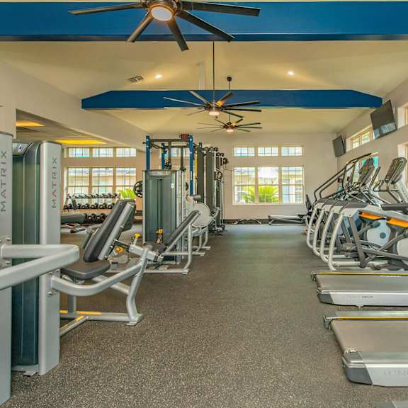 a gym with treadmills, exercise bikes, and a fan. at the cove at state street apartments, baton rouge, la, 70802