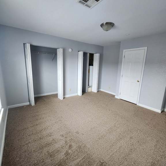 a room with grey walls and carpeted floor.