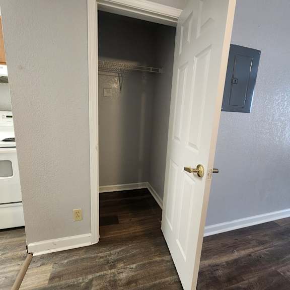 a white door is open to a small kitchen.