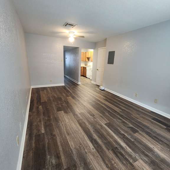 a room with wooden flooring and a door leading to another room.