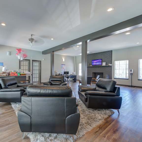 a living room with black leather furniture and a flat screen tv.