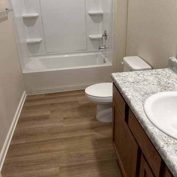 a white toilet sits next to a sink in a bathroom.