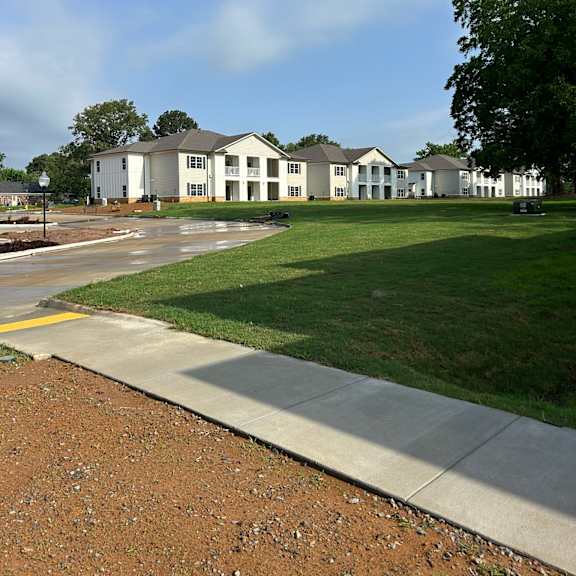 a row of houses with green lawns in front.