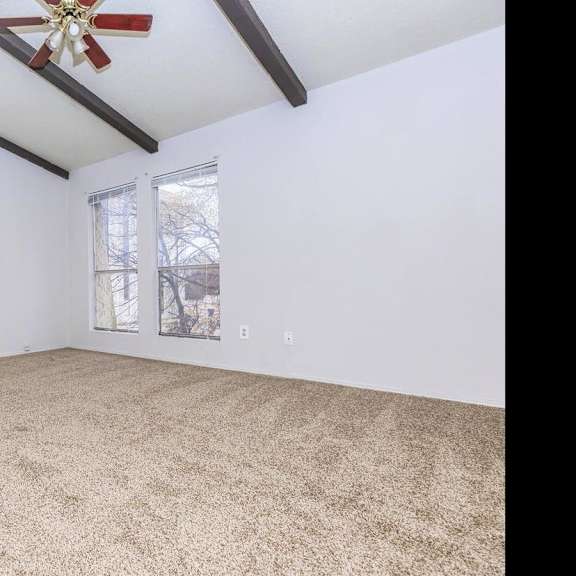 a room with a ceiling fan and a window.