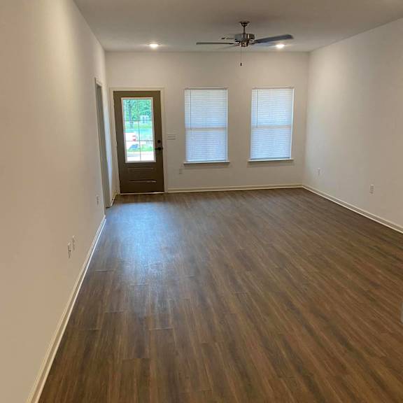 an empty living room with a hard wood floor