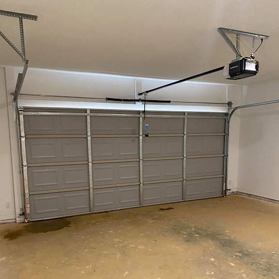 a garage with white doors and a tv on the ceiling