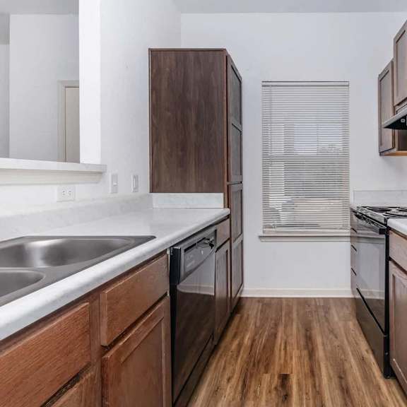 an empty kitchen with a sink and a refrigerator