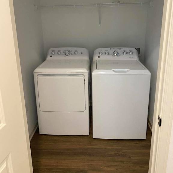 a washer and dryer in a room with a wooden floor
