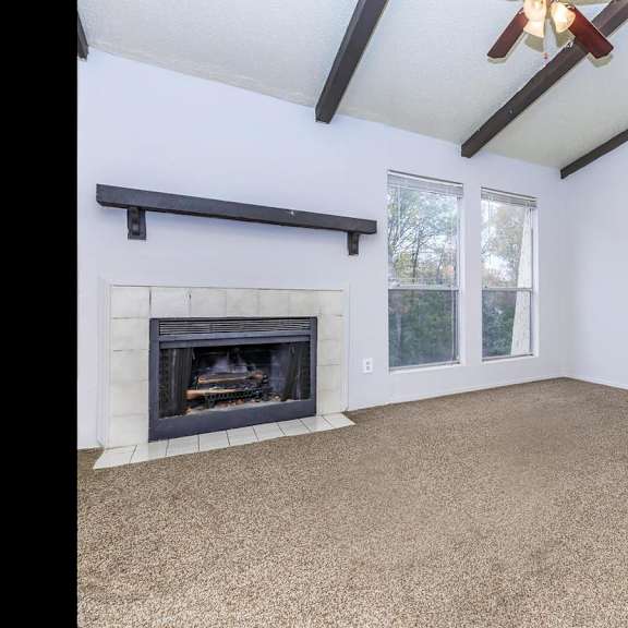 a room with a fireplace and a ceiling fan.