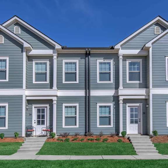 an apartment building with a lawn in front of it