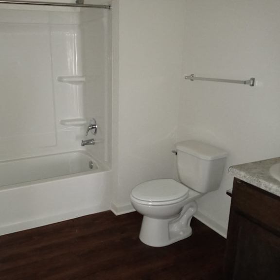 a bathroom with a toilet and a tub and a sink
