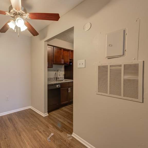 a room with a ceiling fan and a wall-mounted air conditioner unit.