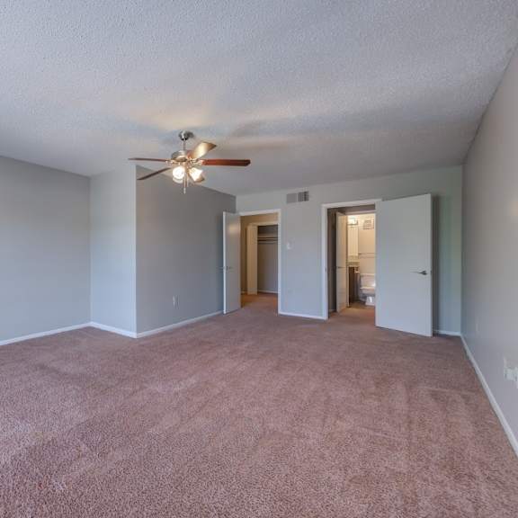 empty room with a ceiling fan and carpeted floor.