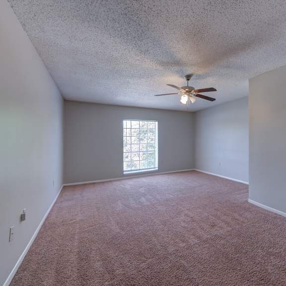 a room with a ceiling fan and a window.