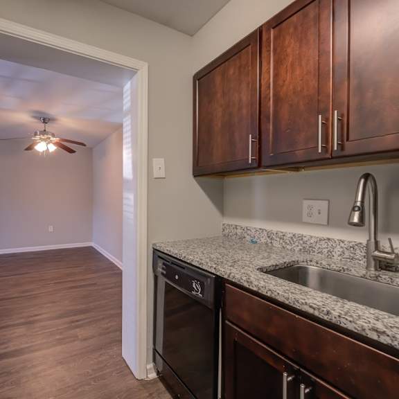 a kitchen with a sink, stove, and cabinets.