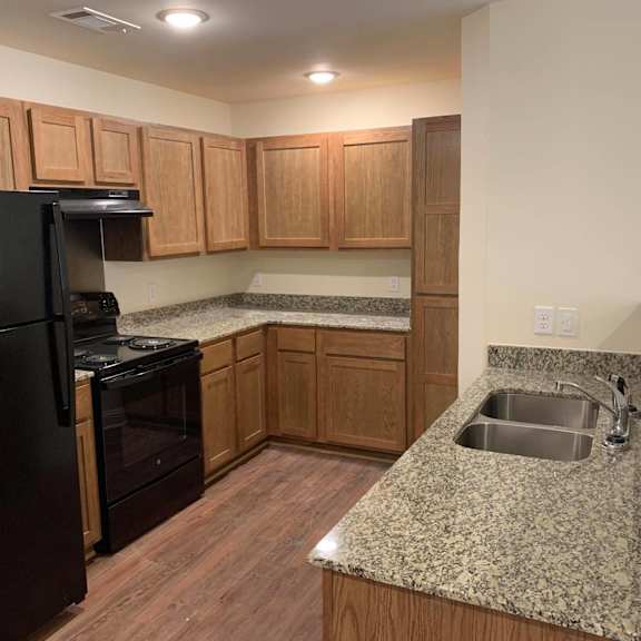 a kitchen with granite counter tops and wooden cabinets